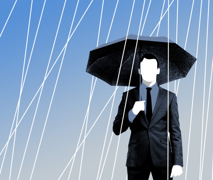 Mann in Anzug steht mit Schirm im Regen